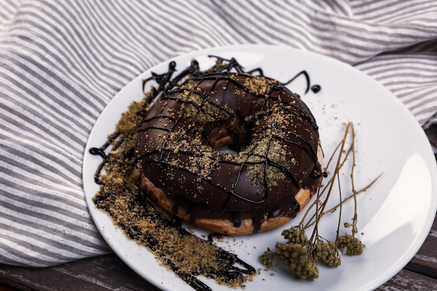 Delicious donut with chocolate sauce and pistachio nut pieces