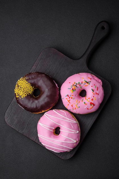 Delicious donut with cream filling and nuts on a dark concrete background