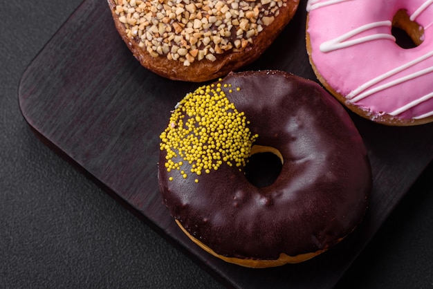 Delicious donut with cream filling and nuts on a dark concrete background