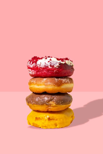Фото Вкусные пончики, изолированные на розовом фоне современная концепция питания реклама для кондитерских кафе