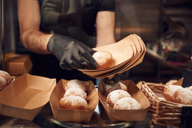 Delicious donuts Man is taking food in the workspace Conception of sweet desserts