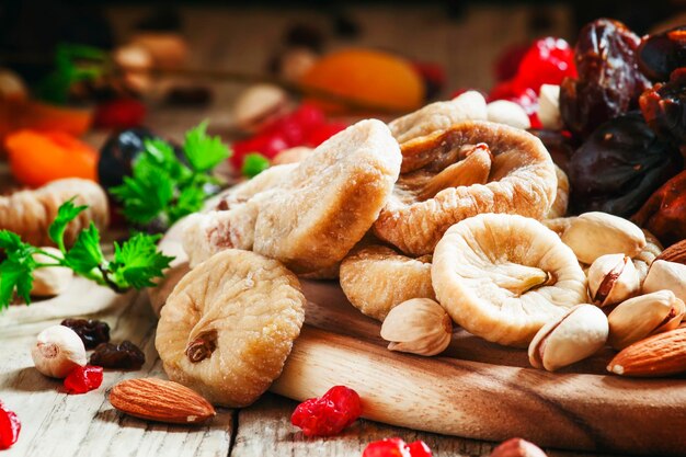 Delicious dried figs and dried fruit and nut mix on dark wooden background in rustic style selective focus