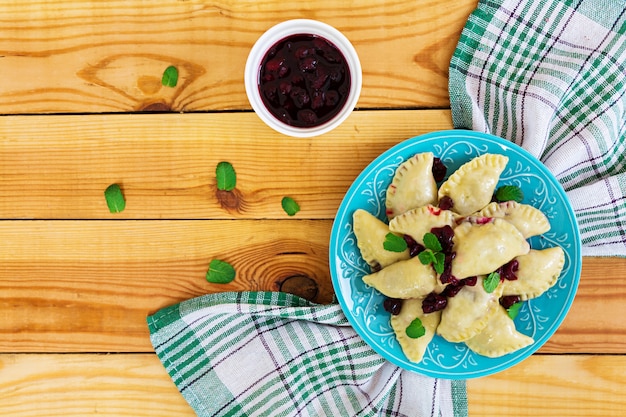 Delicious dumplings with cherry on wooden