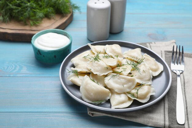 청록색 나무 테이블에 딜이 있는 맛있는 만두