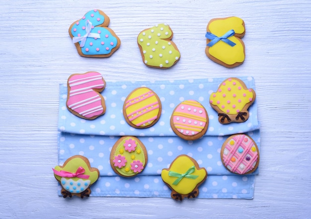 Delicious Easter cookies on blue dotted napkin and white wooden background