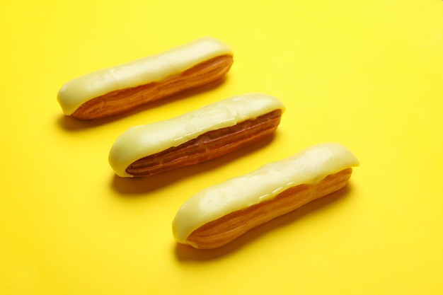 Delicious eclairs with custard on yellow