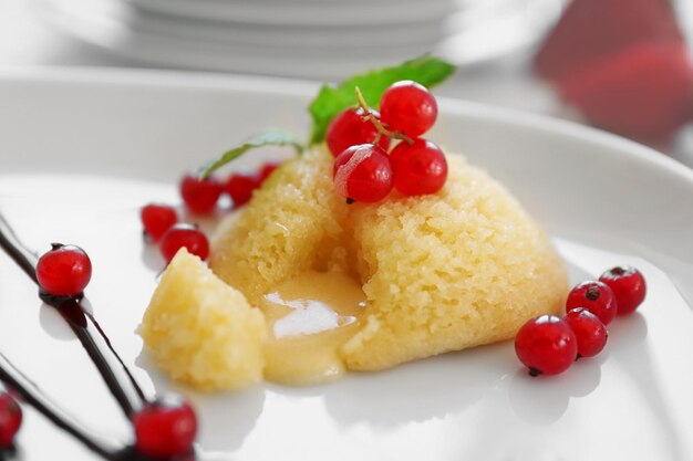 Delicious fondant with red currant on plate closeup