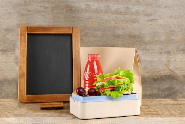 Delicious food in lunch box on wooden background