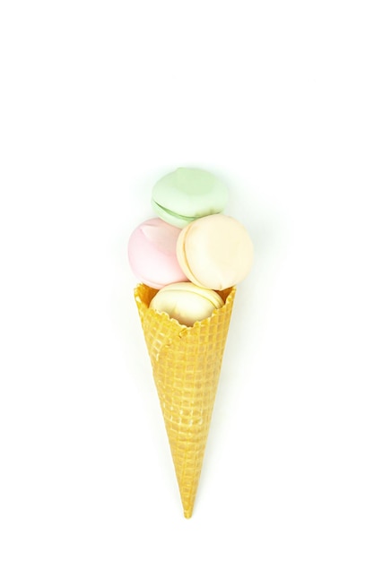 Delicious in the form of a waffle cone filled marshmallows looks like macaroons on a white background