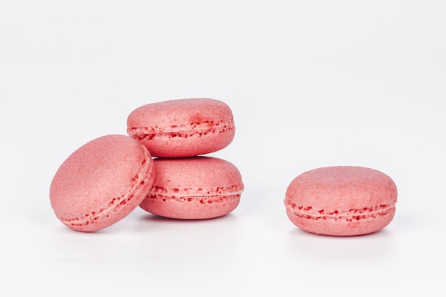 Вкусные четыре розовых Macarons или миндальное печенье, изолированные на белом