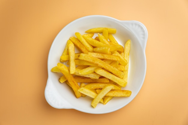 Delicious French fries on an orange background