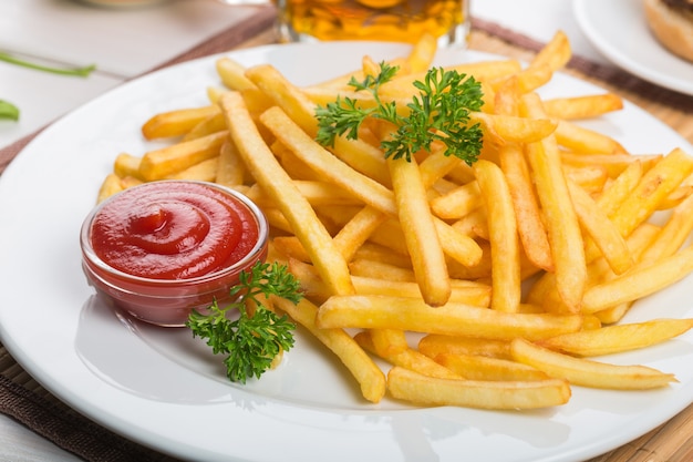 Delicious french fries with sauce on white plate