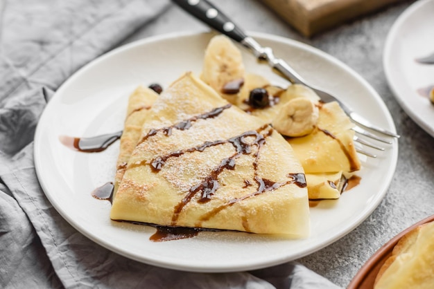 Delicious fresh baked pancakes with honey and fruits on a textured concrete background Useful healthy food