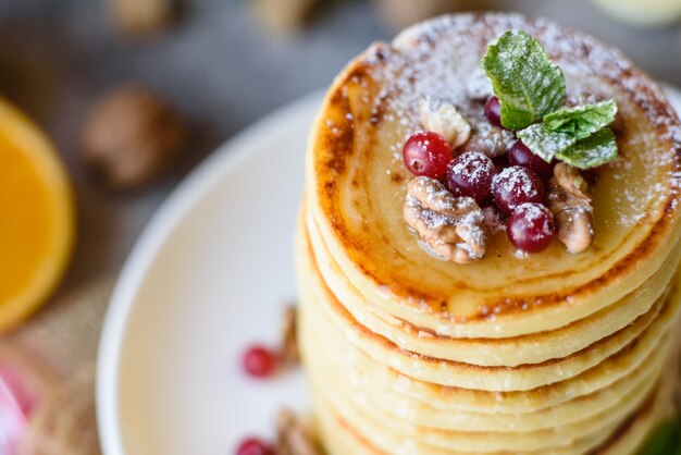 Delicious fresh beautiful pancakes with citrus honey and jam. Delicious hot breakfast with pancakes with fruit and berries