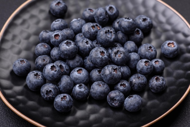 Delicious fresh blueberries on a textural black concrete background