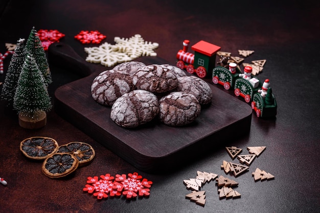 Delicious fresh brownies with Christmas decorations on a dark concrete background