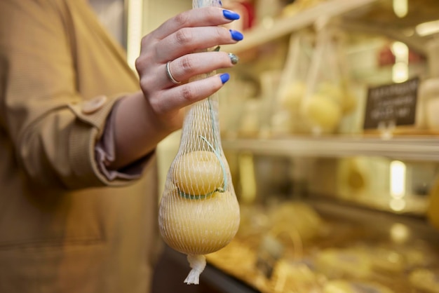 Delicious fresh Caciocavallo and Scamorza cheese hanging Italian cheeses close up The cheeses are handmade The production of cheese