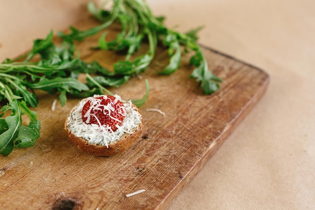 Photo delicious fresh canape with gorgonzola parmezan and strawberry and arugula on wooden desk on craft background