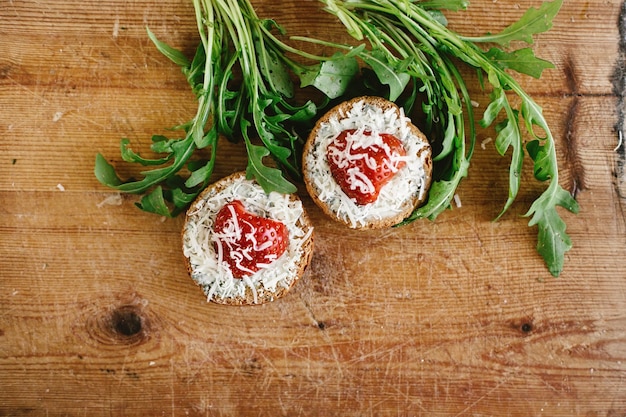 Delicious fresh canape with gorgonzola parmezan and strawberry and arugula on wooden desk top view