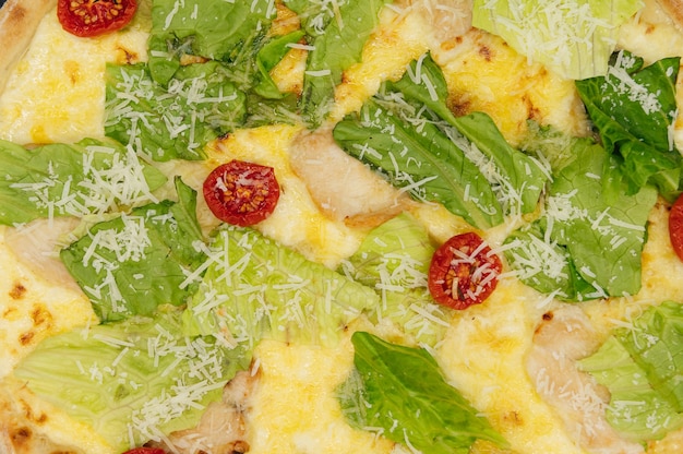 검은 색 표면에 나무 보드에 닭고기와 야채와 함께 맛있는 신선한 세자르 피자