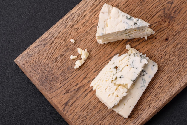 Delicious fresh cheese with blue mold dorblu on a wooden cutting board