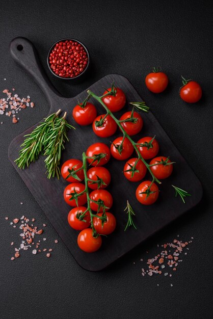 Delicious fresh cherry tomatoes on a twig with spices and herbs