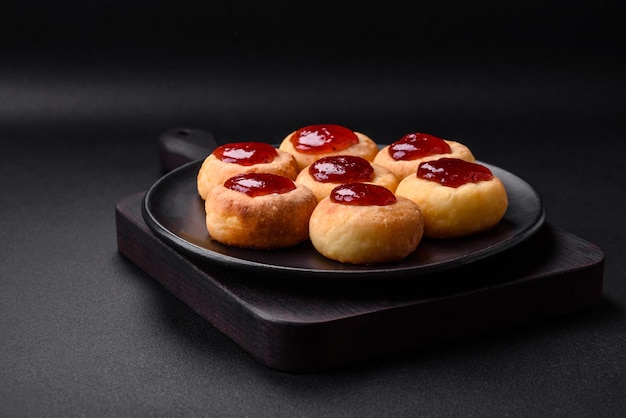 Delicious fresh cottage cheesecakes with raisins and vanilla on a black ceramic plate