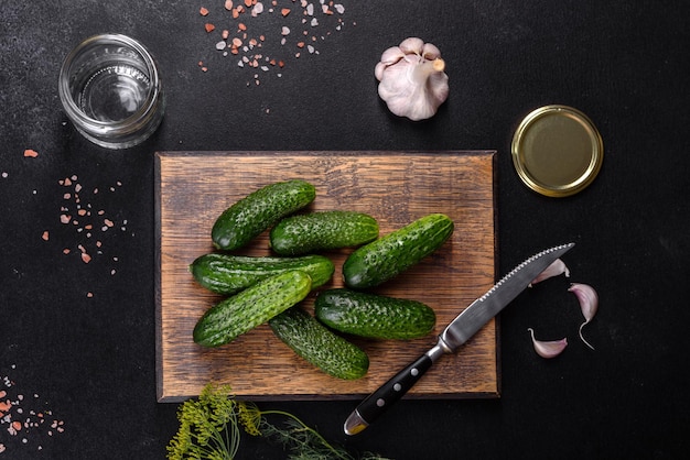 Delicious fresh cucumbers with garlic salt spices and herbs on a wooden cutting board