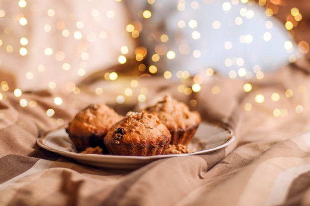 Delicious fresh cupcake with nut on a plate in bed.  