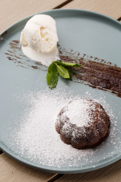 Delicious fresh fondant with hot chocolate and ice cream and mint served on plate.