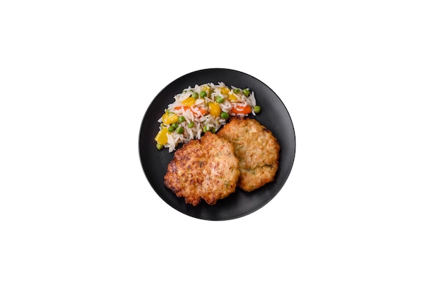 Вкусные свежие жареные котлеты из куриного фарша с солеными специями и травами на темном бетонном фоне