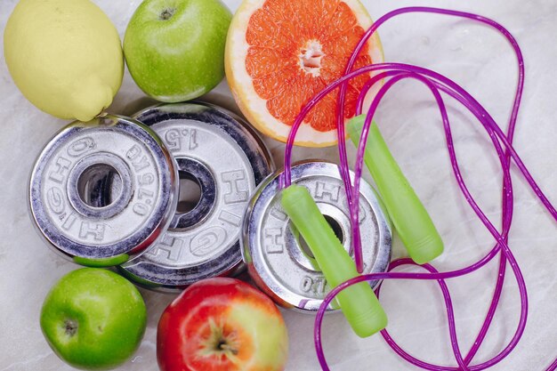 Foto deliziosi frutti freschi sono sul tavolo con peso e bottiglia