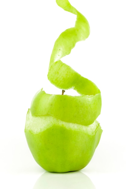 La mela verde deliziosa e fresca sta sbucciando la buccia per poterla mangiare su sfondo bianco