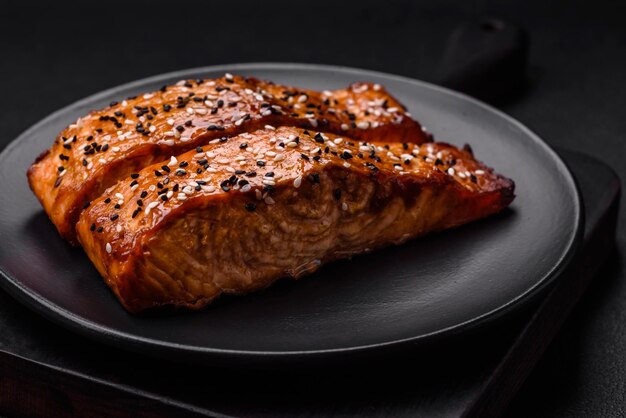 Delicious fresh grilled red fish with salt spices and herbs on a dark concrete background