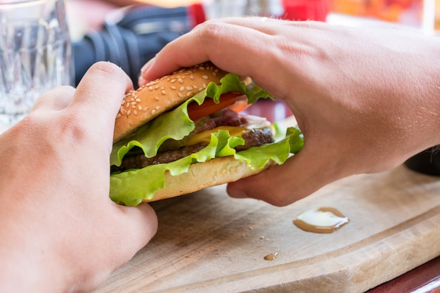 Delicious fresh hamburger with grilled beef burger on a wooden board