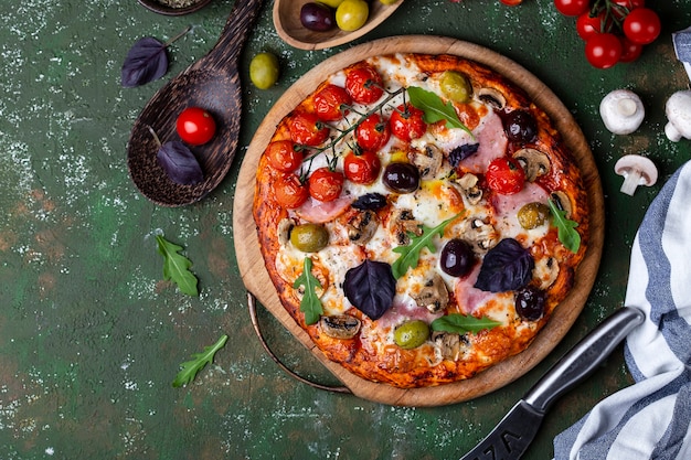 Delicious fresh homemade pizza with ham, mushrooms and tomatoes