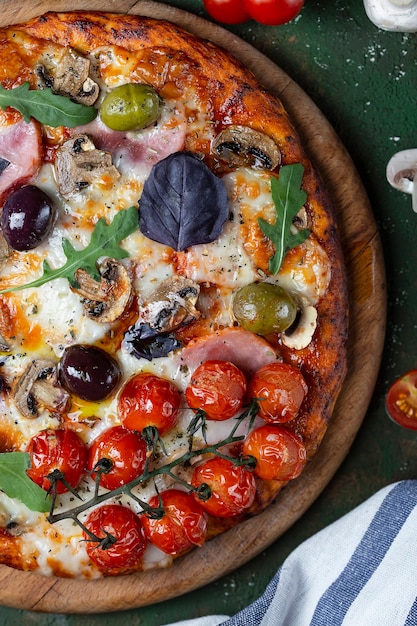 ハム、マッシュルーム、トマトを使ったおいしい新鮮な自家製ピザ