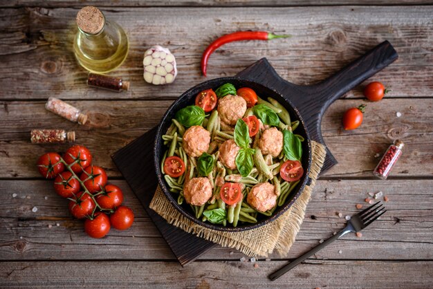 Delicious fresh pasta with meatballs, sauce, cherry tomatoes and basil