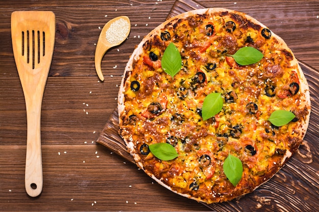 Delicious fresh pizza with chicken, tomatoes, cheese and black olives