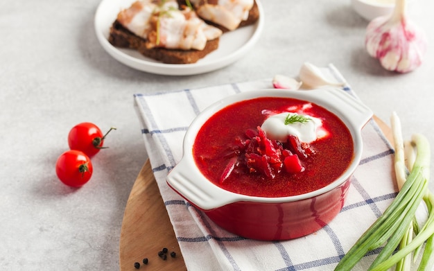 Delicious fresh red borscht dark bread with lard and salt on kitchen table