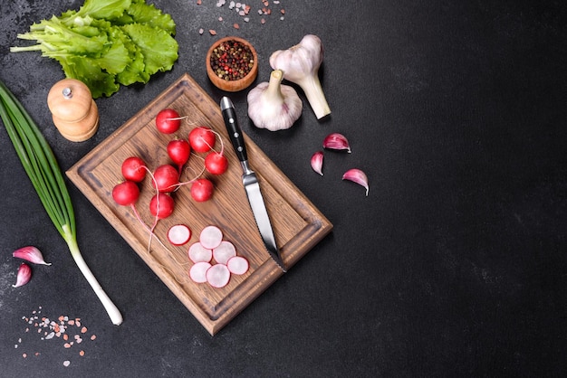 Delicious fresh red radish as ingredient to make spring salad on wooden cutting board