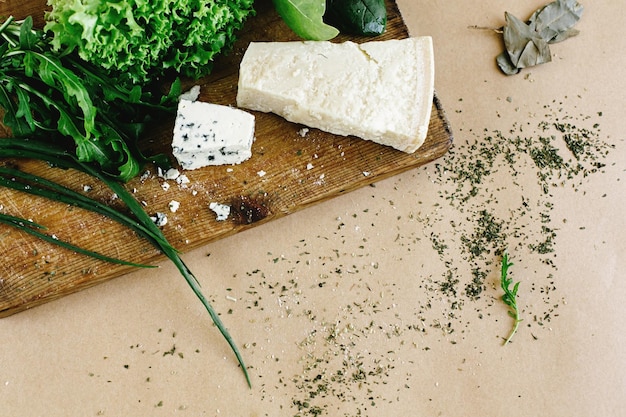 Photo delicious fresh salad arugula spinach and parmezan and gorgonzola cheese on wooden cooking board top view