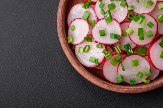 Вкусный свежий салат из нарезанной редиски с зеленым луком, солью и оливковым маслом