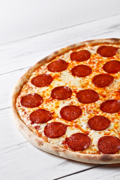 Delicious fresh salami pizza served on wooden table