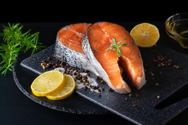 Delicious fresh salmon with lemon salt and spices on a black\
table concept of healthy seafood