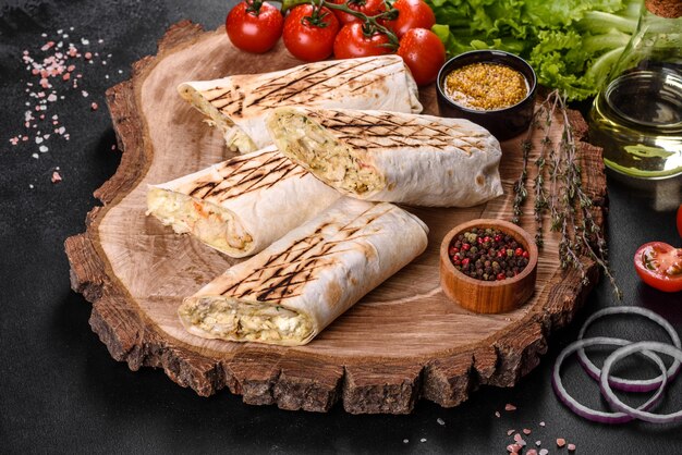 어두운 콘크리트 테이블에 고기와 야채와 함께 맛있는 신선한 shawarma. 패스트 푸드, 터키 요리