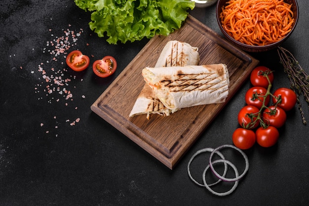 Delicious fresh shawarma with meat and vegetables on a dark concrete table. Fast food, Turkish cuisine