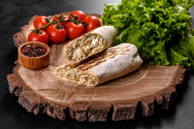 어두운 콘크리트 테이블에 고기와 야채와 함께 맛있는 신선한 shawarma. 패스트 푸드, 터키 요리