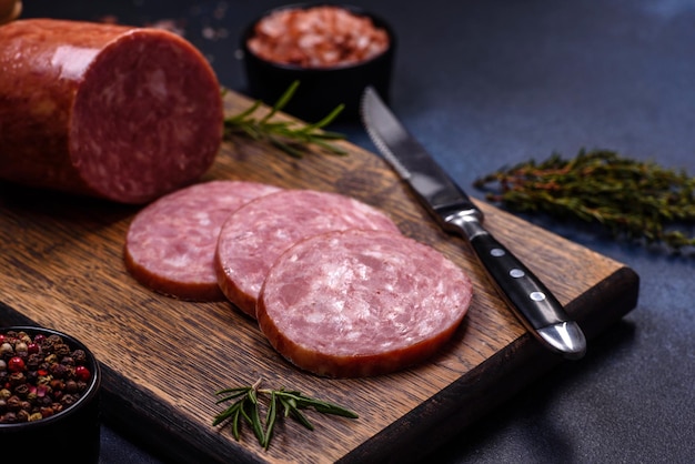 Delicious fresh smoked sausage cut with slices on a wooden cutting board