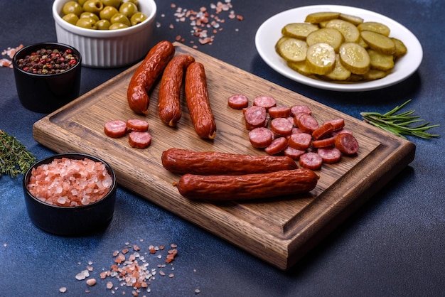 Delicious fresh smoked sausages cut with slices on a wooden cutting board